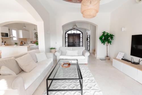 Modern Villa in El Gouna (Private Pool & Garden.) في الغردقة: غرفة معيشة مع أريكة بيضاء وطاولة