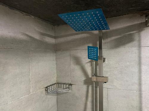 a shower with a blue object in a bathroom at The Residence Golden Tulip 2 Bedroom Apartment, Amuwo Lagos, Nigeria in Lagos