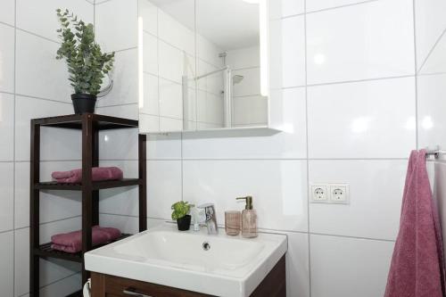 a white bathroom with a sink and a mirror at RELAX-ROSÉ mit Pool und Sauna in Scheidegg