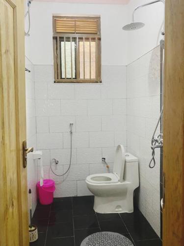 uma casa de banho com um WC e uma janela em Kyaliwajala Heights Apartment em Kampala