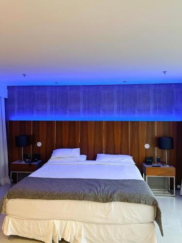 Un dormitorio con una cama grande con luces azules. en Propriedade privada no Hotel Nacional Rio de Janeiro en Río de Janeiro