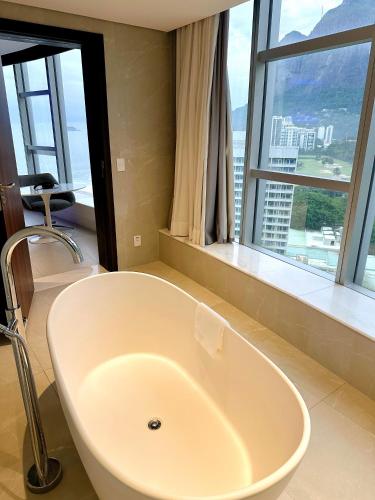 uma banheira na casa de banho com uma grande janela em Propriedade privada no Hotel Nacional Rio de Janeiro no Rio de Janeiro