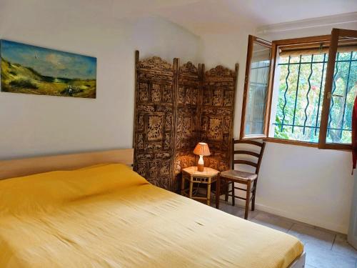 a bedroom with a bed and a table and a window at Antibes Port de Salis Appart 3p in Antibes