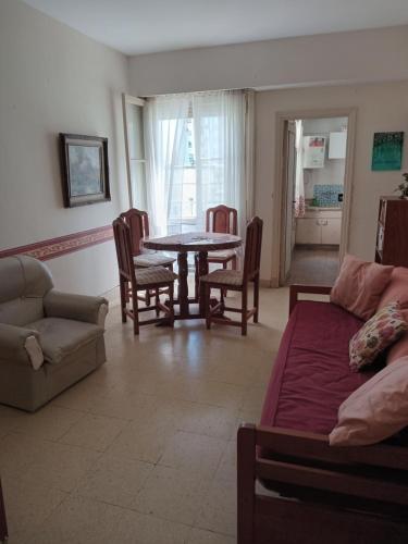 sala de estar con mesa y sofá en depto pleno centro a 3 cuadras del mar en Mar del Plata
