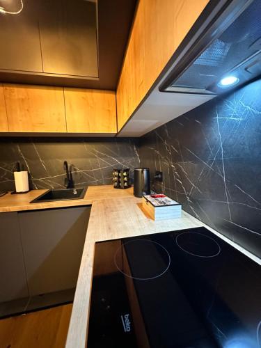 a kitchen with wooden cabinets and a counter top at WinterHome2 in Bjelašnica