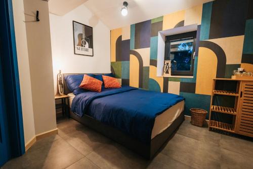 a bedroom with a bed with blue sheets and colorful walls at Nasza Chata in Duszniki Zdrój