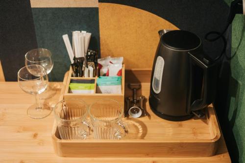 a coffee maker on a wooden tray with wine glasses at Nasza Chata in Duszniki Zdrój