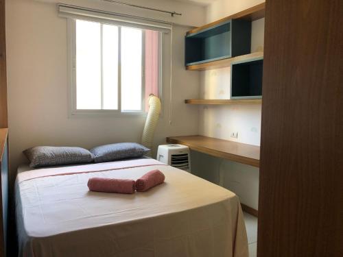 une chambre avec un lit avec une fenêtre et une table dans l'établissement Apartamento Pérola - Zona Sul de Ilhéus - 200 m da praia, à Ilhéus