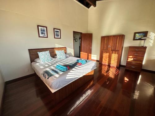 um quarto com uma cama grande e almofadas azuis em Latui Lodge em Savusavu