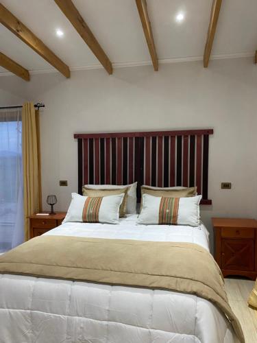 a large bed with a wooden headboard in a bedroom at Patagua Valley Lodge in Santa Cruz
