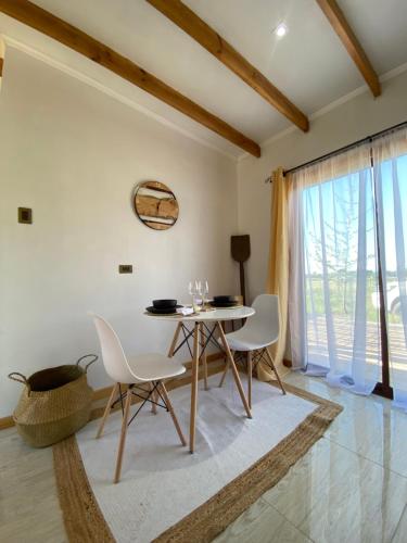a dining room with a table and white chairs at Patagua Valley Lodge in Santa Cruz