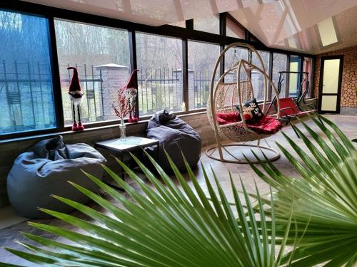 uma sala de estar com baloiços e uma planta de palmeira em Glory em Truskavets
