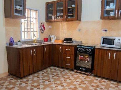 a kitchen with wooden cabinets and a stove top oven at CORAL PLACE in Abeokuta