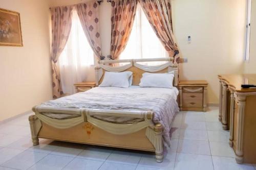 um quarto com uma cama grande e uma janela em CORAL PLACE em Abeokuta