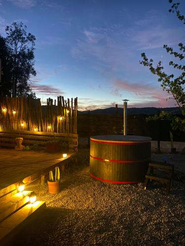 a lit up area with a table and a bench at Patagua Valley Lodge in Santa Cruz