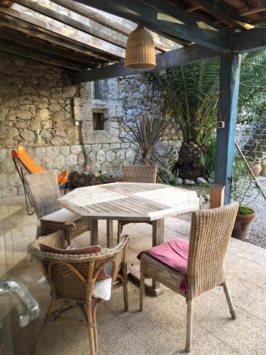 Une table et des chaises en bois sont disponibles sur la terrasse. dans l'établissement Jolie maison entre mer et Narbonne, à Narbonne