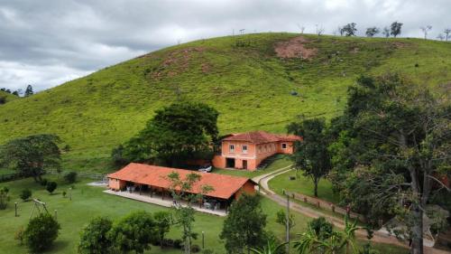 a house in front of a green hill at Pousada Campestre Cunha-SP in Cunha