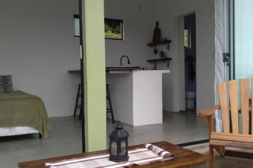 ein Wohnzimmer mit einem Tisch und einer Küche in der Unterkunft Bem Vindo Ao Presente in Igrejinha