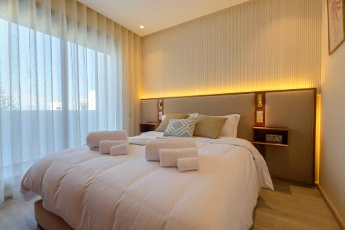 a bedroom with a large white bed with a large window at Appartement luxueux et lumineux Maarif Casablanca in Casablanca