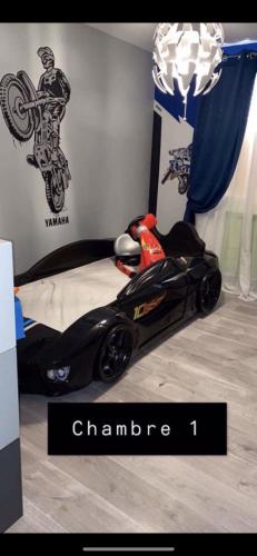 - une voiture de race noire sur un lit dans une chambre dans l'établissement T4 morgiou/prado, à Marseille