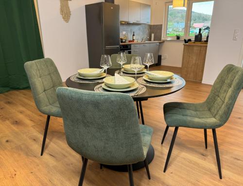 a dining room table and chairs with plates and wine glasses at Home Inn Apartments - 203 in Minden