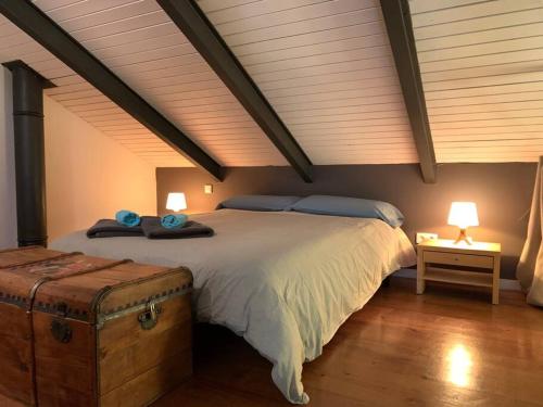 um quarto com uma cama grande, 2 candeeiros e um baú. em La Cata Country House em Patones
