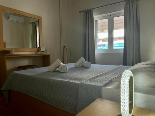 a bedroom with a bed with towels on it at SYRIOS House & Apartments in Nafplio