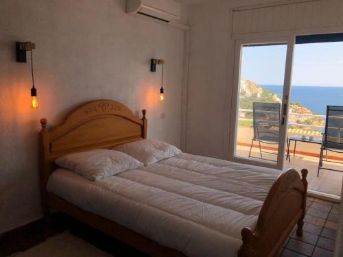 Schlafzimmer mit einem Bett und Meerblick in der Unterkunft Joan Timoneda Agradable villa con vistas al mar y 2 parking in Roses