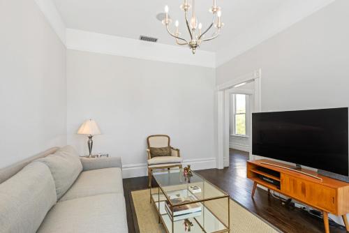 a living room with a couch and a flat screen tv at Minimalistic 1885 Queen Anne Cottage 2B-2B Upper Level Flat in Alameda in Alameda