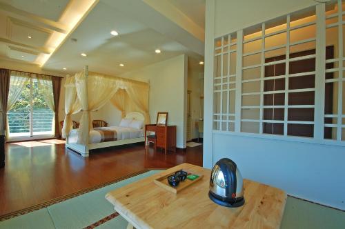a room with a bedroom with a bed and a table at Ti Siang B&B in Ren'ai