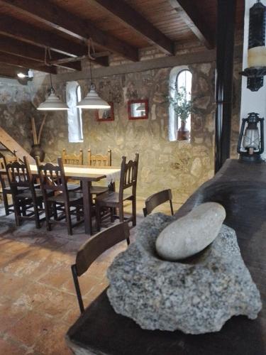 - une salle à manger avec une table, des chaises et un grand rocher dans l'établissement Don Alejandro, à Córdoba