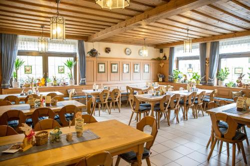 un restaurante con mesas y sillas de madera y ventanas en Brauerei Gasthof Reblitz, en Bad Staffelstein