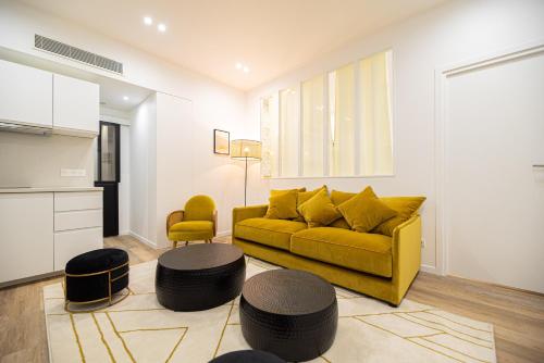 un salon avec un canapé jaune et une table dans l'établissement Cosy home - Haut marais, à Paris
