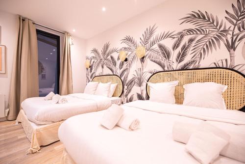 - 2 lits dans une chambre avec papier peint tropical dans l'établissement Cosy home - Haut marais, à Paris