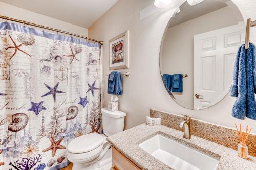 a bathroom with a toilet and a sink and a mirror at Seconds from the Sand, Unit 312 in Westport
