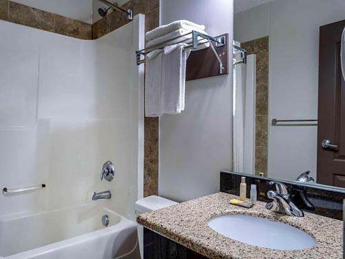 a bathroom with a sink and a toilet and a tub at Travelodge by Wyndham Wetaskiwin in Wetaskiwin