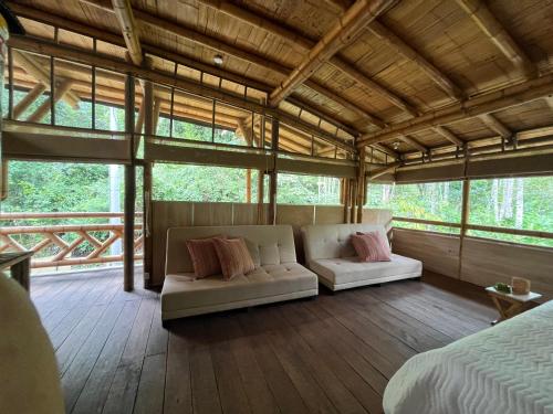 a bedroom with a bed and a couch in a room at Oasis Santuario de Naturaleza in Ibagué