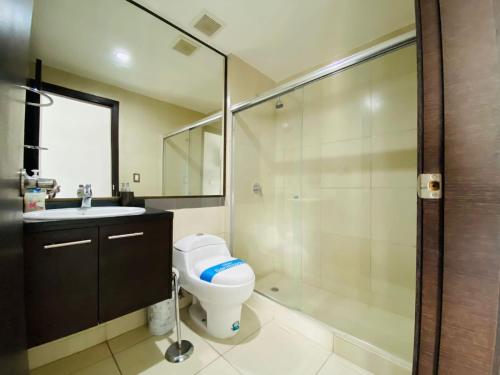 a bathroom with a toilet and a sink and a shower at Luxury Suite Wifi & Pool in Guayaquil