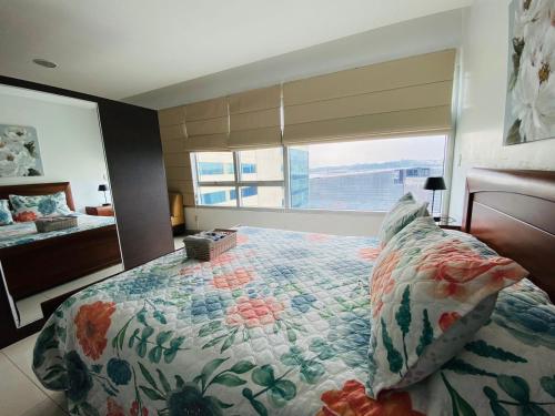 a bedroom with a bed and a large window at Luxury Suite Wifi & Pool in Guayaquil