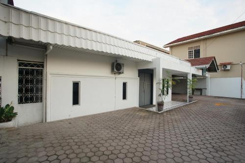 a white house with a brick driveway at Hotel Bhakti Syariah in Padang