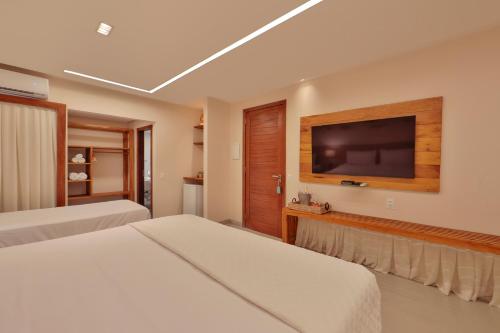 um quarto com 2 camas e uma televisão de ecrã plano em Pousada Humaitá em Japaratinga