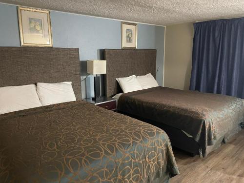 a hotel room with two beds and blue walls at Safari Motel in Nephi