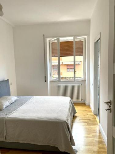 - une chambre blanche avec un lit et une fenêtre dans l'établissement Lucilio - intero appartamento, à Rome