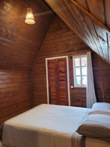 a bedroom with two beds in a wooden room at Chalés Conexão Bahia in Amontada