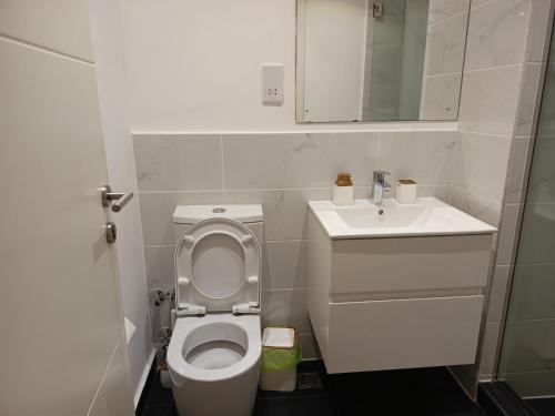 uma pequena casa de banho com WC e lavatório em Just Nice Stays @ The Gardens em Acra