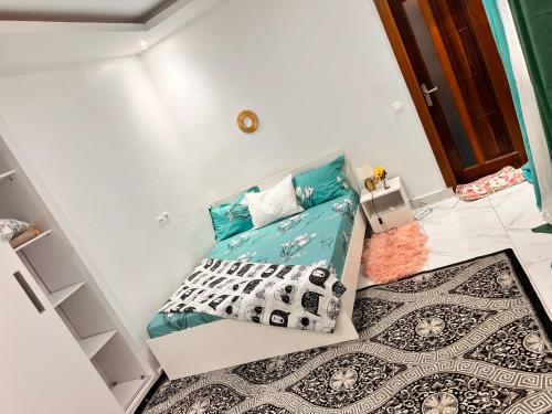 een kleine kamer met een bed en kussens bij LUXE Appartement in Dakar