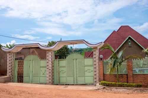 a house with green garage doors and a red roof at AUTOP BG Guest House in Kigali