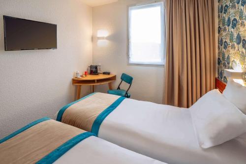 a hotel room with two beds and a desk at Sure Hotel by Best Western Sarlat-la-Canéda in Sarlat-la-Canéda