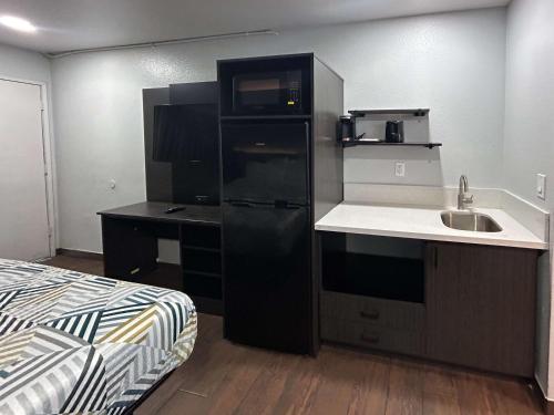 a kitchen with a sink and a black refrigerator at Studio 6 Hemet, CA in Hemet