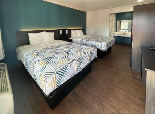 a hotel room with two beds and a bathroom at Studio 6 Hemet, CA in Hemet